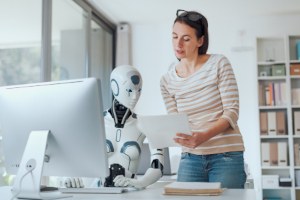 Frau arbeitet mit KI-Roboter zusammen